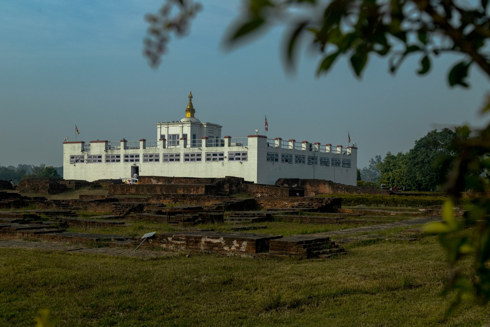 Ancient monastic ruins and prayer flags at Maya Devi Temple